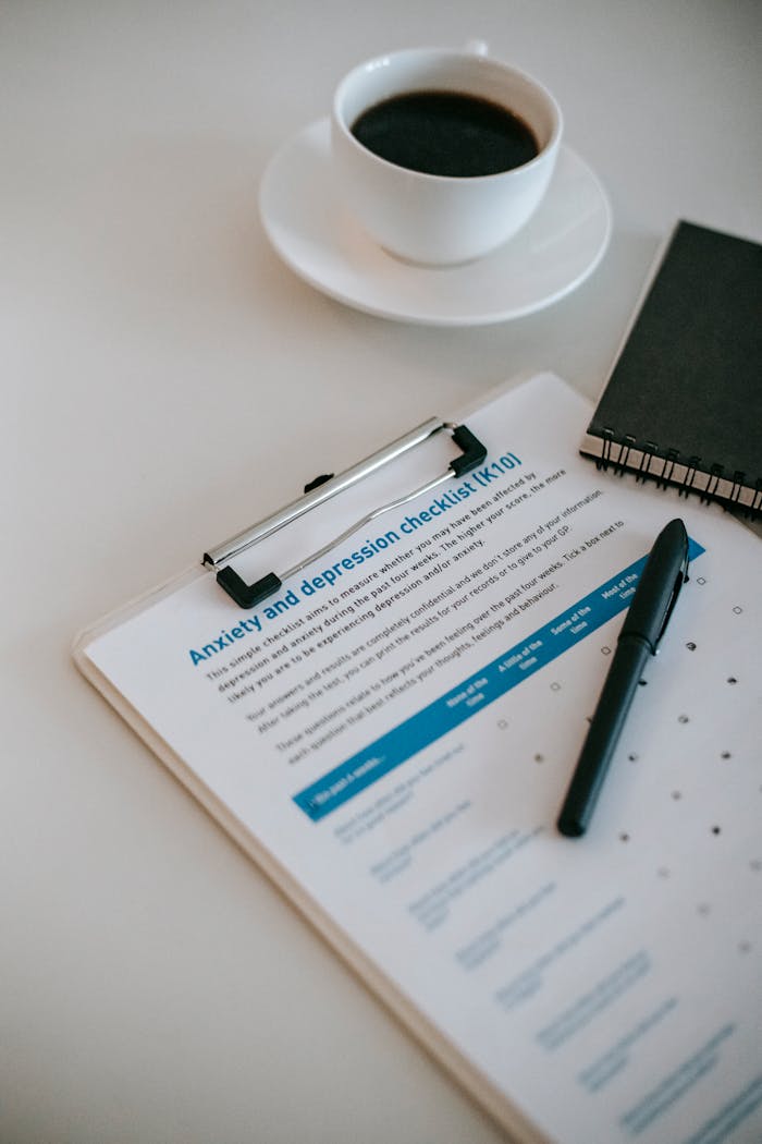From above of cup of hot coffee on table with clipboard and notepad in office of psychologist